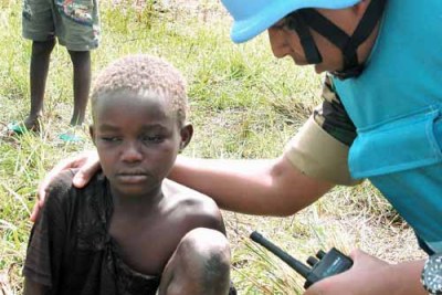 Un élément des Nations Unies au secours d'un enfant affecté par la guerre à l'Est du Congo.