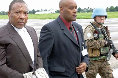 Charles Taylor, left, being transferred for trial at The Hague in the Netherlands.