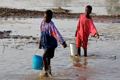 Children carrying water through a river in Ghana.