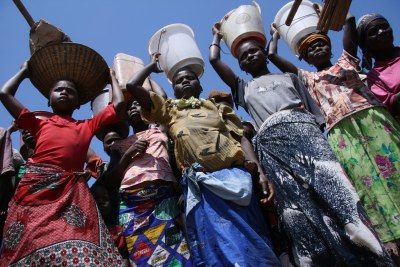 Women with belongings on their heads taking part in a flood simulation exercise.