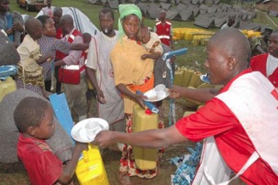 A young boy receives relief items from workers of the Uganda Red Cross society.