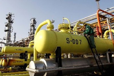 A worker checks machinery and pipelines for oil production.