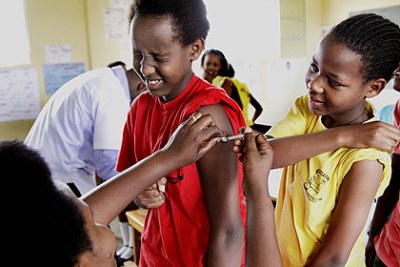 Seraphine Mukanyarwaya, Nurse at Kagugu Health Centre Immunizing pupils of Apapec Irebero Primary School.