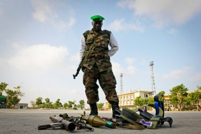 A soldier stands over the weapons seized from suspected members of Al Shabaab (file photo).