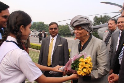 An Indian student welcomes President Ellen Johnson Sirleaf with flowers.