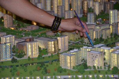 Painting finishing touches onto a model city display of Abuja