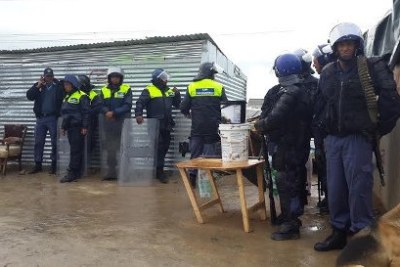 Police officers prepare to oversee the destruction of shacks (file photo).