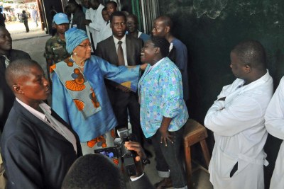 President Sirleaf consoles a health worker at the Redemption Hospital as they mourn the death of a colleague who died of Ebola.