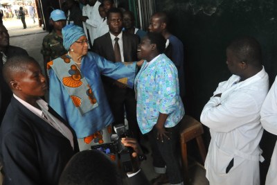 President Sirleaf consoles a health worker at the Redemption Hospital as they mourn the death of their colleague, Esther Kesselee, who died of Ebola.