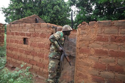 Un Casque bleu africain inspecte une maison abandonnée dans l’un des nombreux villages le long d’une route au sud de Bossangoa, en République centrafricaine.