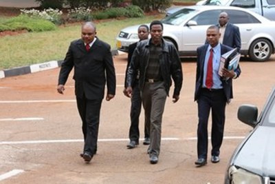 Former war veterans leader Jabulani Sibanda (centre) escorted by police detectives.