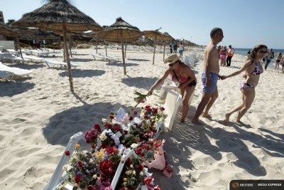 Des touristes déposent des gerbes de fleurs à la mémoire des disparues lors de l'attaque terroriste qui s'est produite sur cette plage de Sousse.