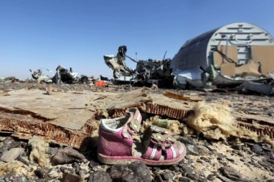 A child's shoe is seen in front of debris from a Russian airliner which crashed at the Hassana area in Arish city, north Egypt.