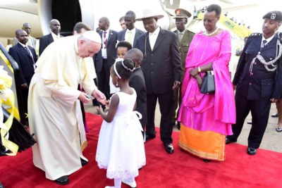 Jasmine Bamwine receives a gift from Pope Francis on his arrival at Entebbe airport.