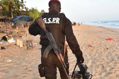 A soldier in neighboring Cote d'Ivoire patrols the Grand Bassam beach resort following a terrorist attack on the facility.