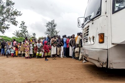 Des réfugiés burundais attendant devant un bus au centre d’accueil de Bugesera avant leur transfert vers le camp de réfugiés de Mahama, au Rwanda.