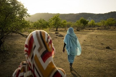 Two women walk in the Nuba Mountains