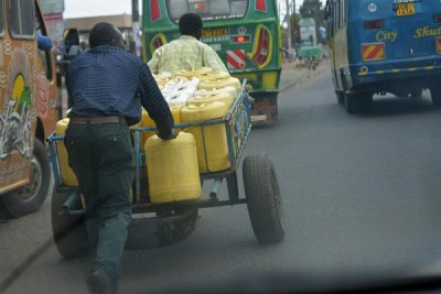 Vendors carry water to a customer in Nairobi on February 6, 2017.