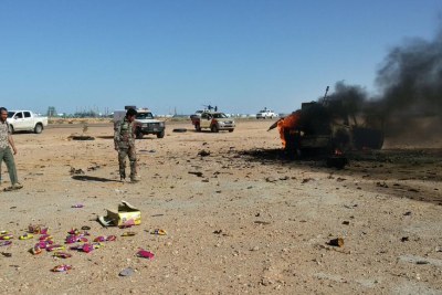 Un véhicule en feu après des affrontements entre l'armée libyenne et des combattants des Brigades de défense de Benghazi, à Ras Lanuf le 14 mars 2017.