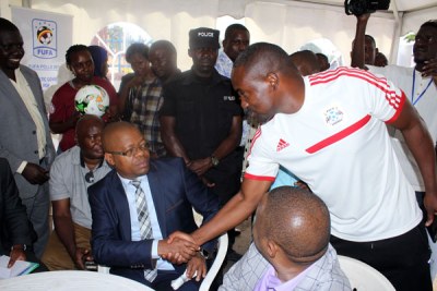 Friends or foes? Incumbent Fufa president Moses Magogo shakes hands with Mujib Kasule after both candidates picked nomination forms for Fufa presidency.