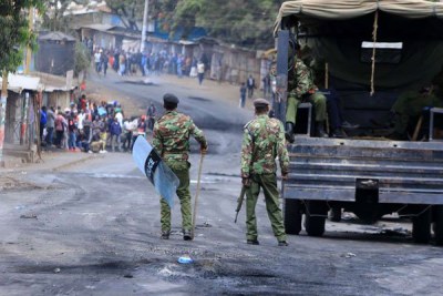 Police officers patrol Kibra streets in Nairobi on August 12, 2017 during protests by residents.