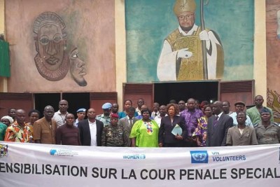 Des participants à un atelier de sensibilisation au sujet de la Cour pénale spéciale tenu le 30 octobre 2017 à Bossangoa (préfecture d’Ouham) en République centrafricaine, photographiés devant une banderole concernant cet évènement.