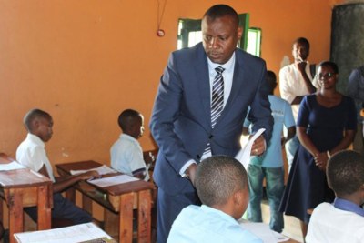 Education Minister Isaac Munyakazi distributes exam papers at GS Kacyiru I at the start of the exams.