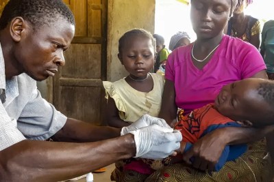 A community health worker carries out a rapid diagnostic test for malaria.