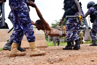 This photo taken on November 18, 2020 shows police manhandling one of Robert Kyagulanyi's supporters near Nalufenya police post in Jinja where he [Kyagulanyi] was taken after his arrest (file photo)