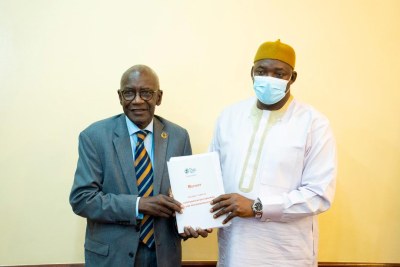 Truth commision president Lamin Sise (left) hands over his final report to President Adama Barrow (Right).