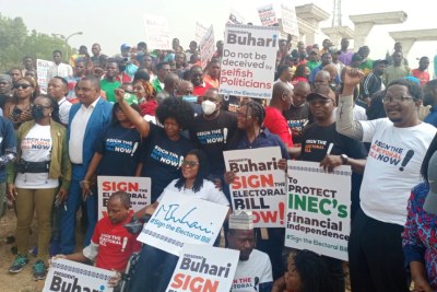 Protesters from various civil society groups hold placards in Abuja demanding president Buhari to sign the electoral bill in Abuja On Tuesday, February 22, 2022.