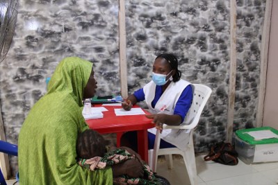 MSF nurse listening to a caretaker in MSF out-patient Department (OPD) clinic in Emir Palace camp for Internally Displaced People.