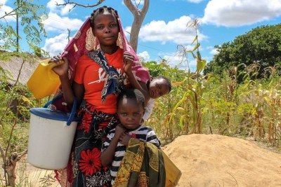 Une mère et ses enfants, qui ont été déplacés par les violences, vont chercher de l'eau dans un camp temporaire dans le district de Montepuez, Cabo Delgado, Mozambique.